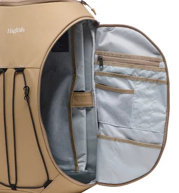 Inre organisering beige ryggsäck med gråa fickor, mesh-fack och Haglöfs-logotyp