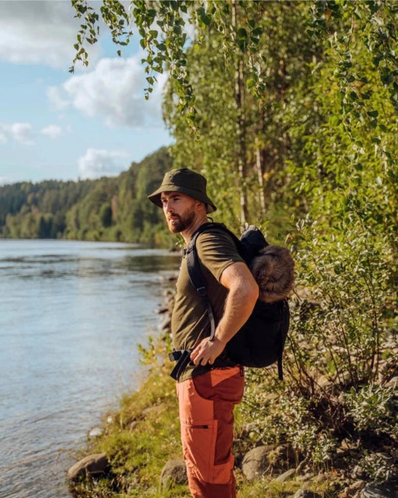 Mörkgrön InsectSafe hatt vid sjöstrand med ryggsäck