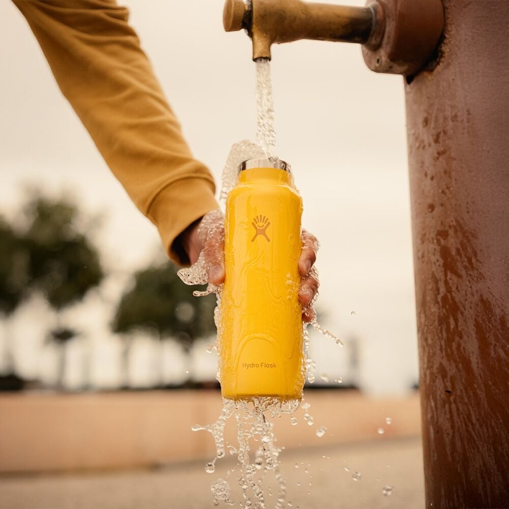 Gul Hydro Flask vattenflaska under rinnande vatten för att visa rengöring