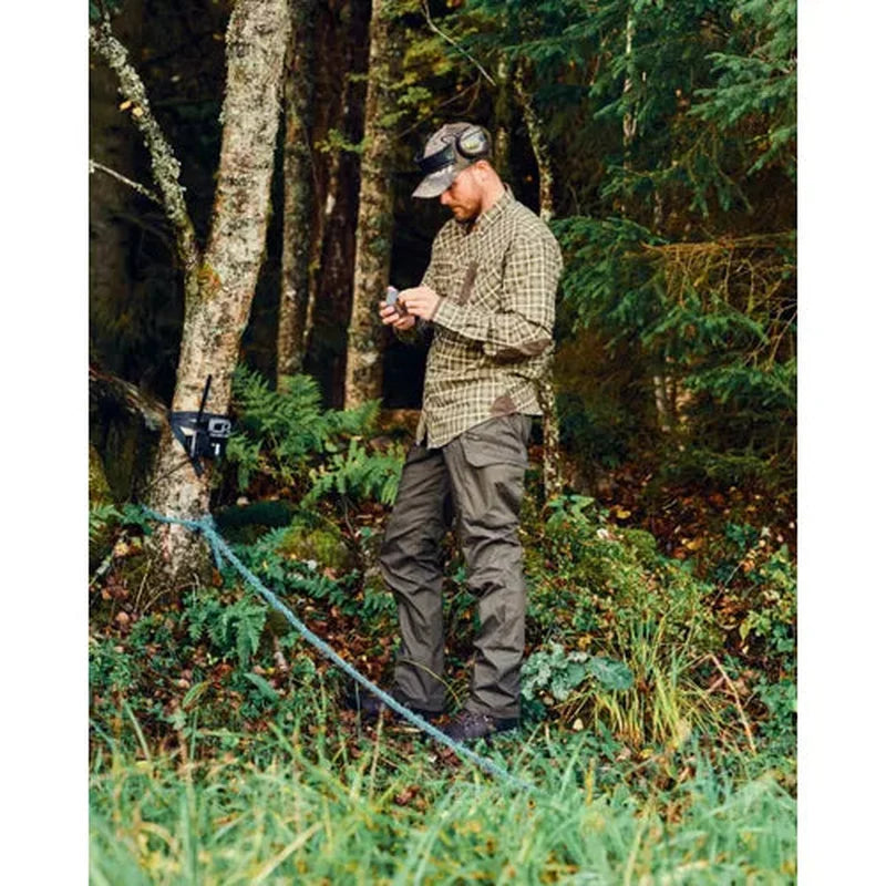 Man i mörkgröna InsectSafe byxor vid fällfälla i skogen