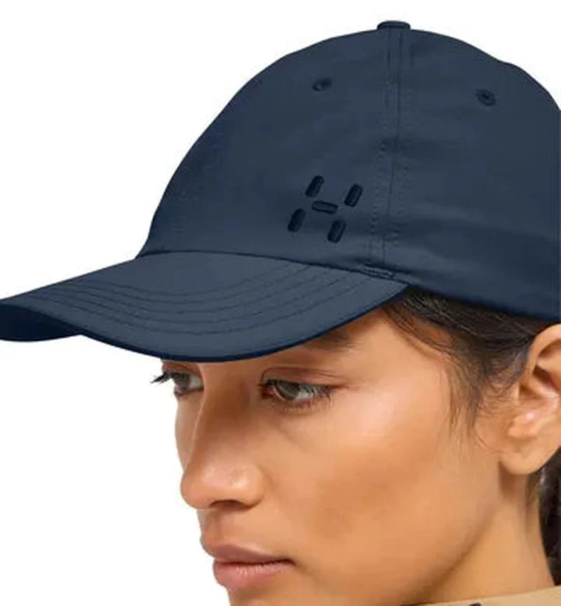 Närbild på mörkblå Haglöfs keps med utskuren logo och ventilationshål