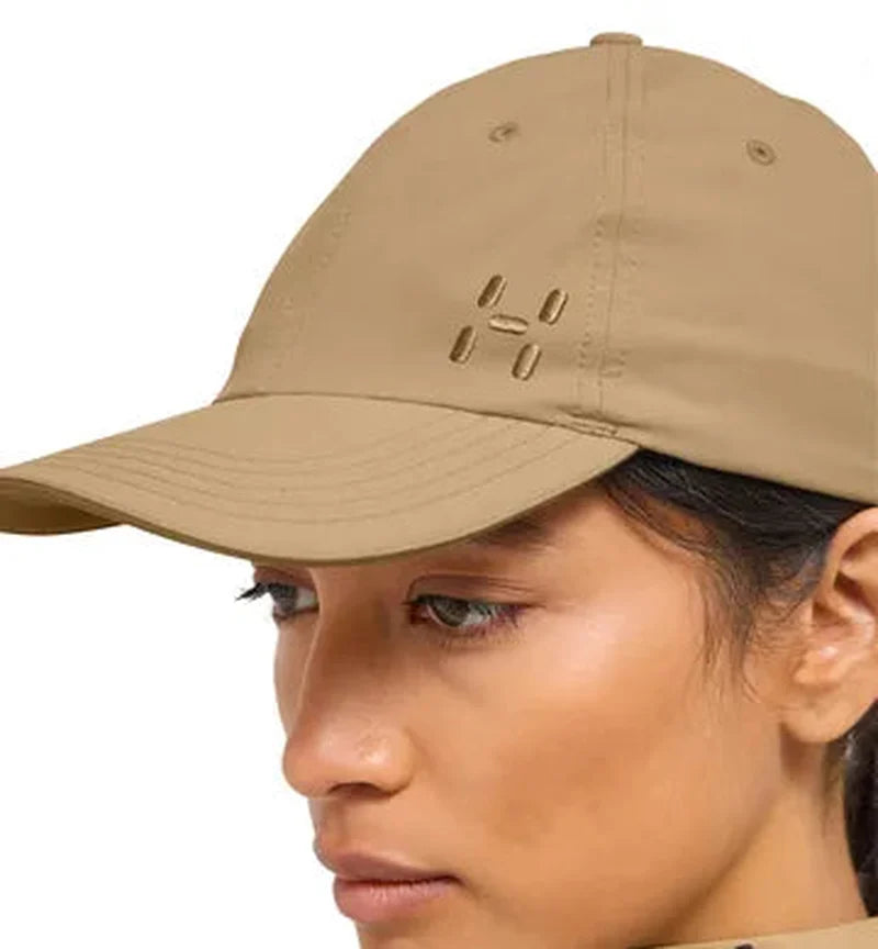 Profilbild av mörkblå Haglöfs keps med utskuren logo och ventilerade hål