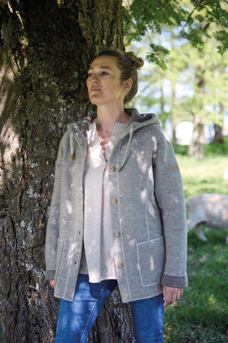 Ljusgrå stickad ulljacka buren utomhus mot natur