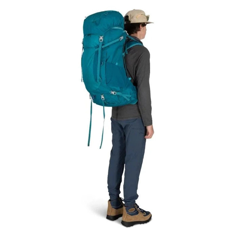 Person som bär teal Osprey Ace 65 juniorvandringryggsäck väl anpassad