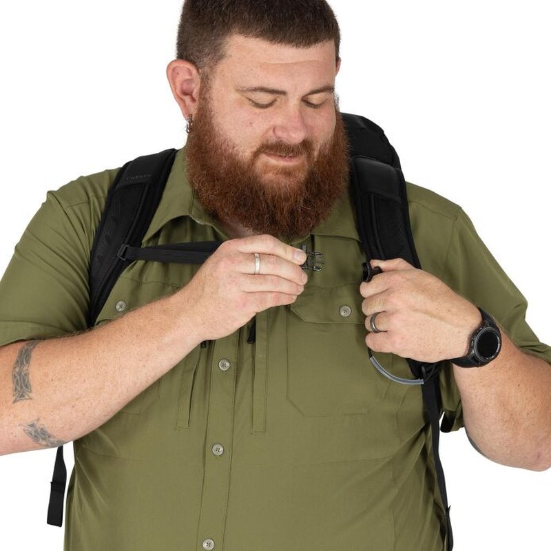 Man justerar svart Osprey Talon 33 ryggsäck med hydrationsslang