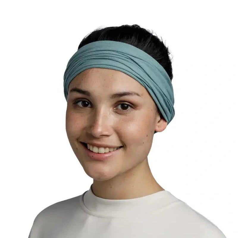 Kvinna som bär teal Buff Original Ecostretch som huvudband