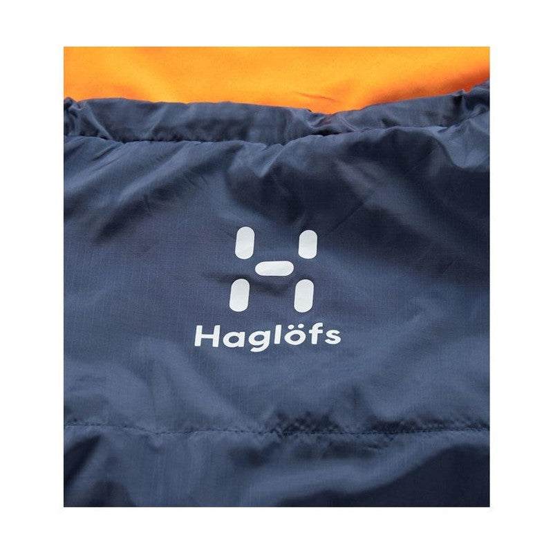 Mörkblå Haglöfs-sovsäck med tryckt vit logotyp och synligt orange inre foder vid kanten