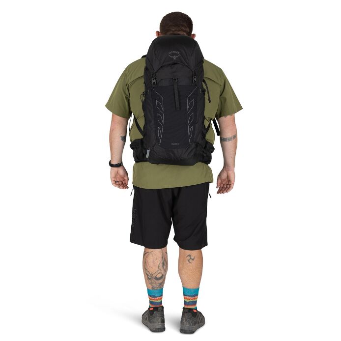 Bakvy av man som bär svart Osprey Talon 33 ryggsäck