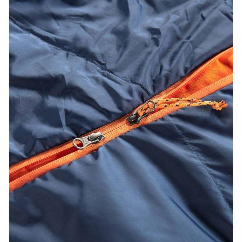 Detaljbild av orange dragkedja med metallspänne på mörkblå sovsäck