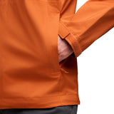 Hand i sidofacket på orange skaljacka med fästrem