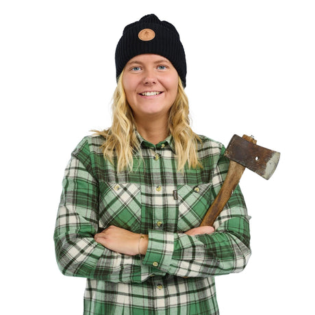 Dam som bär grönvit flanellskjorta med friluftsrörsax