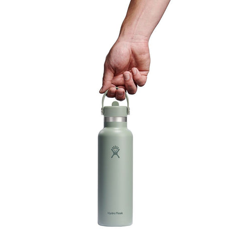 Ljusgrön Hydro Flask vattenflaska hållen i bärhandtaget för storleksreferens